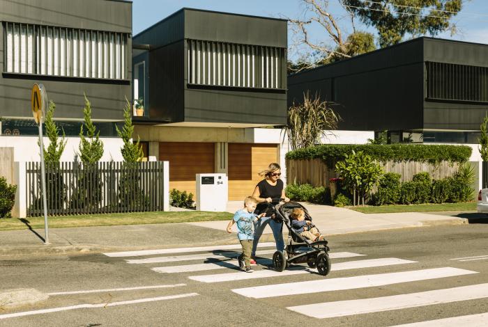 Photo of lady with child crossing residential street